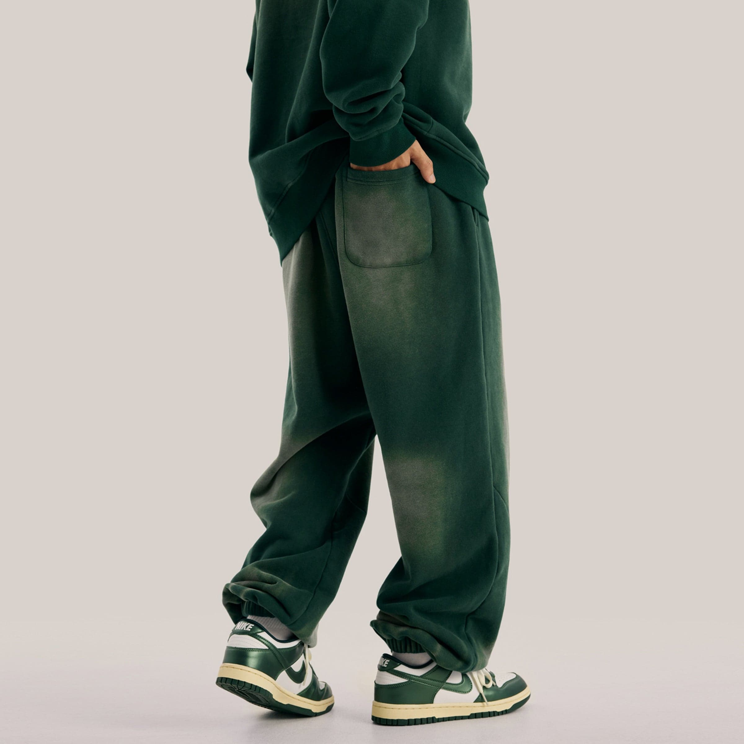 Akant Noir embroidered sweatpants side and back pocket fit view on model in green sample color