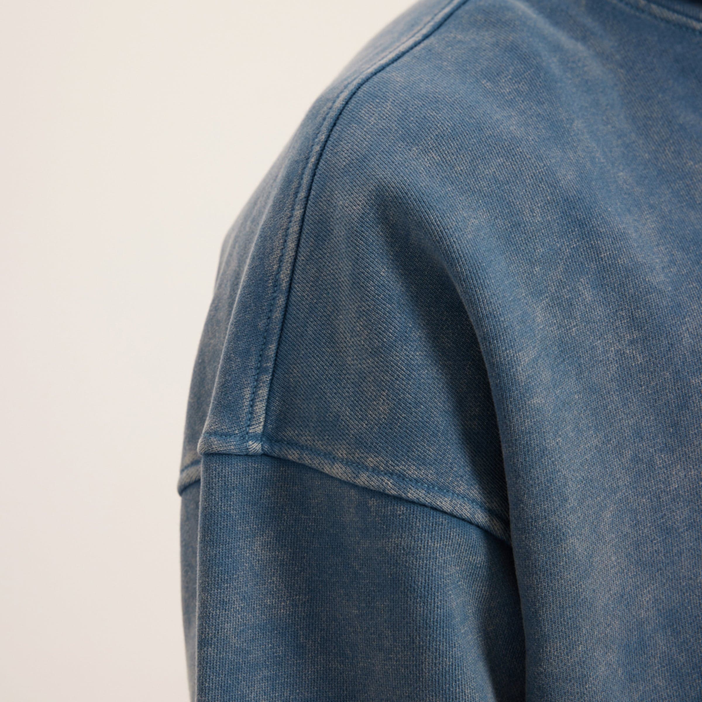 washed blue hoodie shoulder seam close up detail