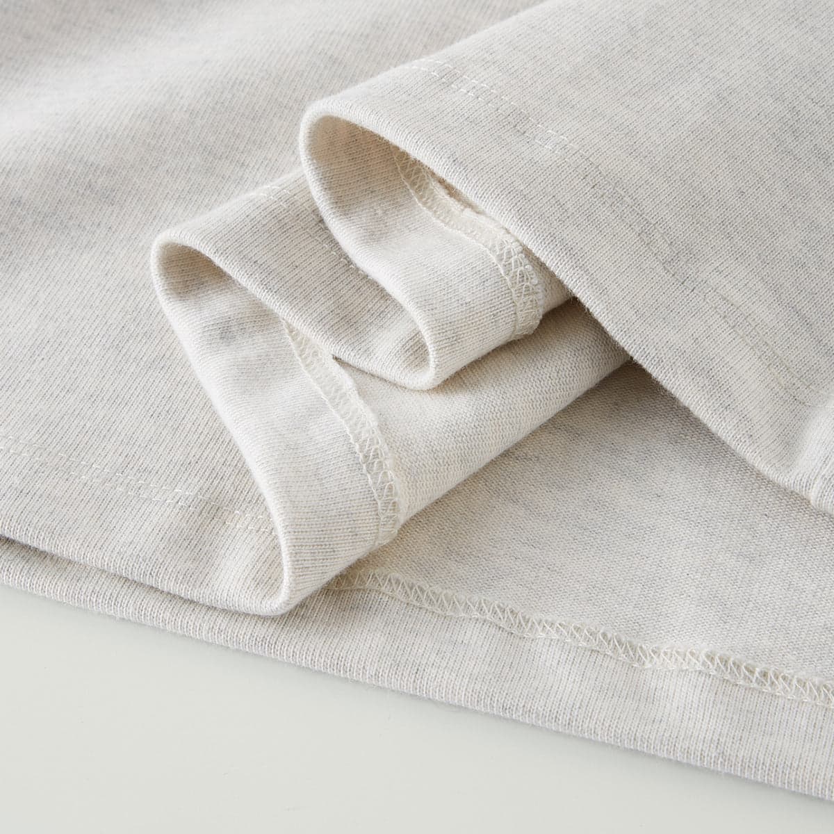 AURA oversized graphic tee folded sleeve and hem close-up detail
