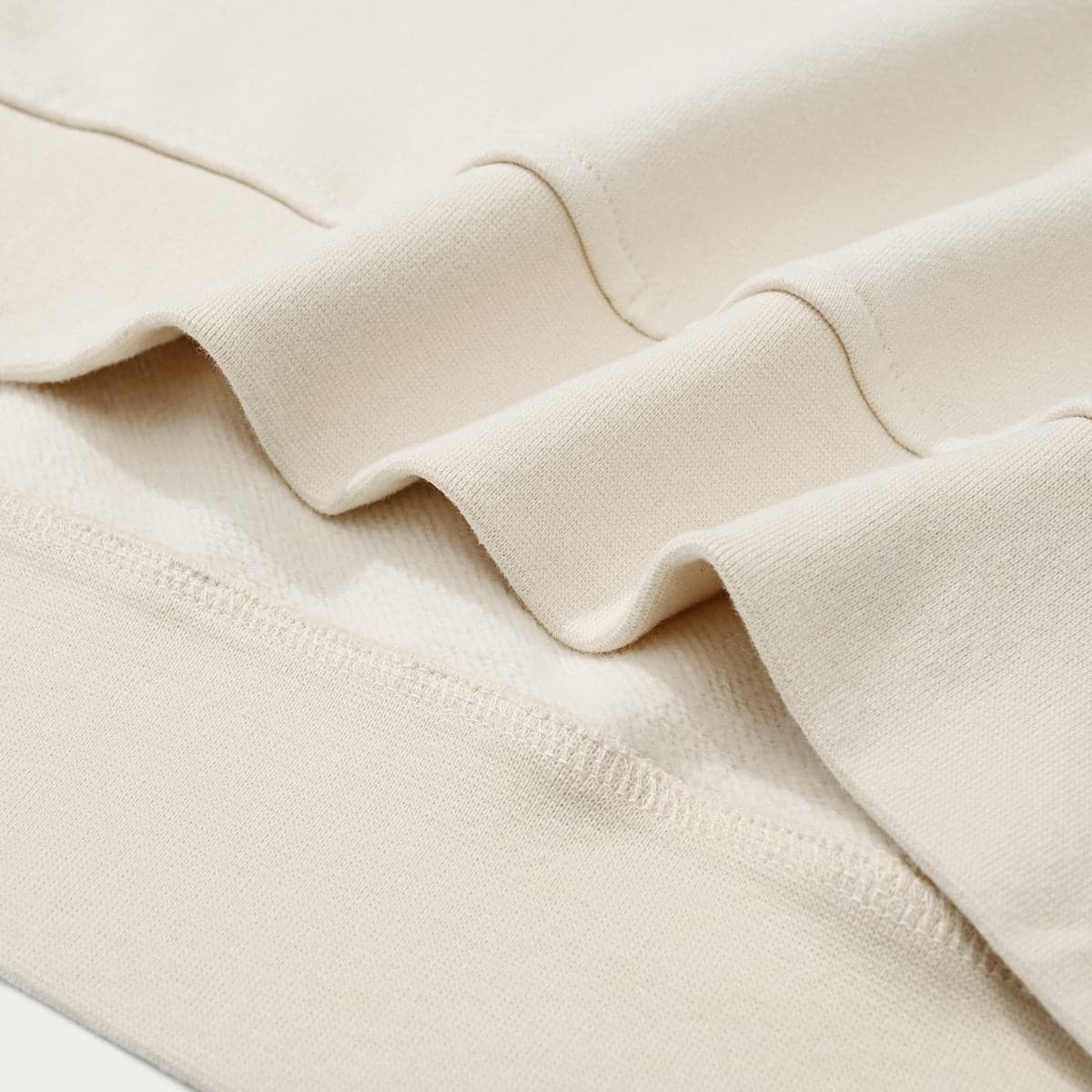 AURACORE graphic half-zip sweatshirt folded hem detail in cream fabric