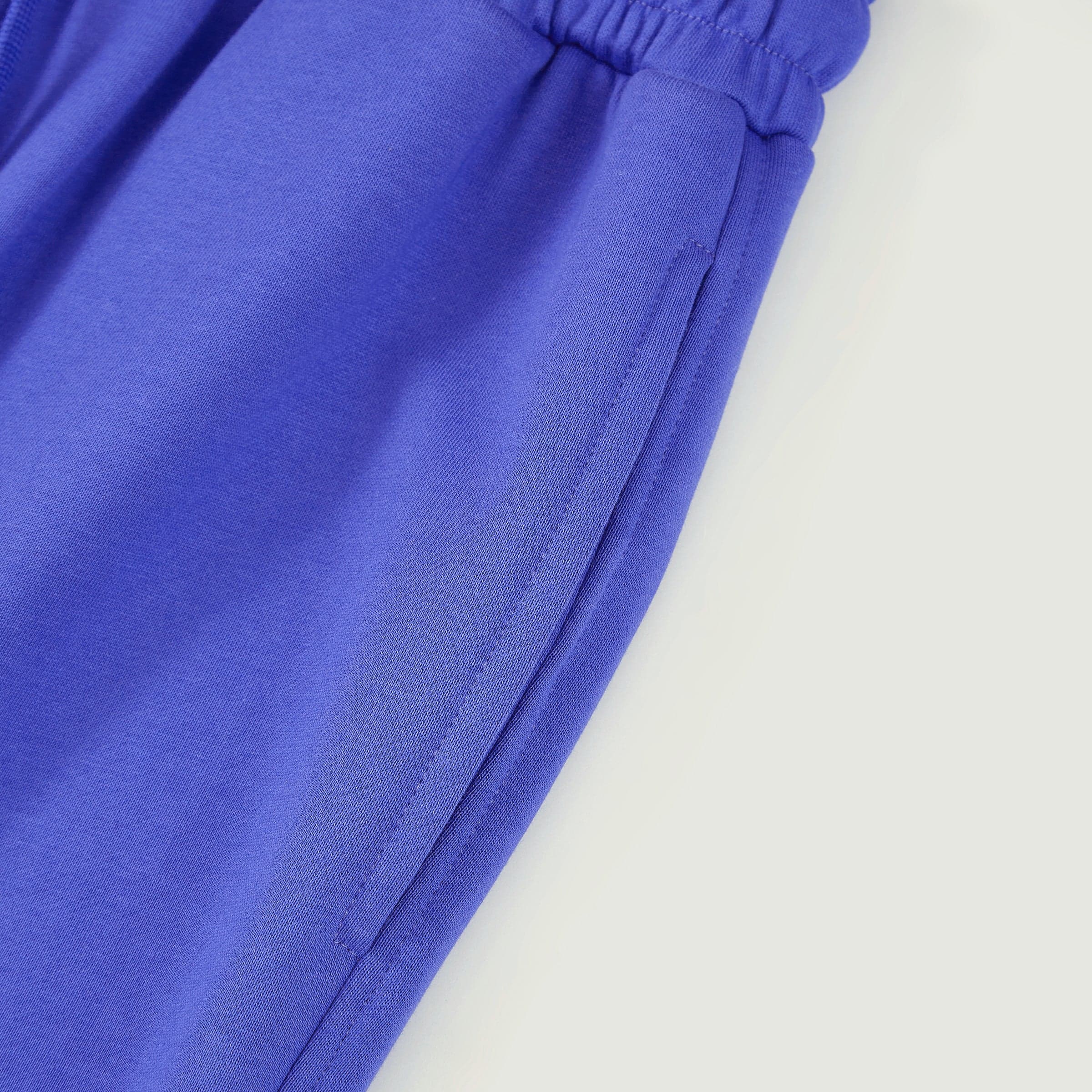 DRGN FLUX media image showing blue sample sweatpants upper leg seam close-up detail