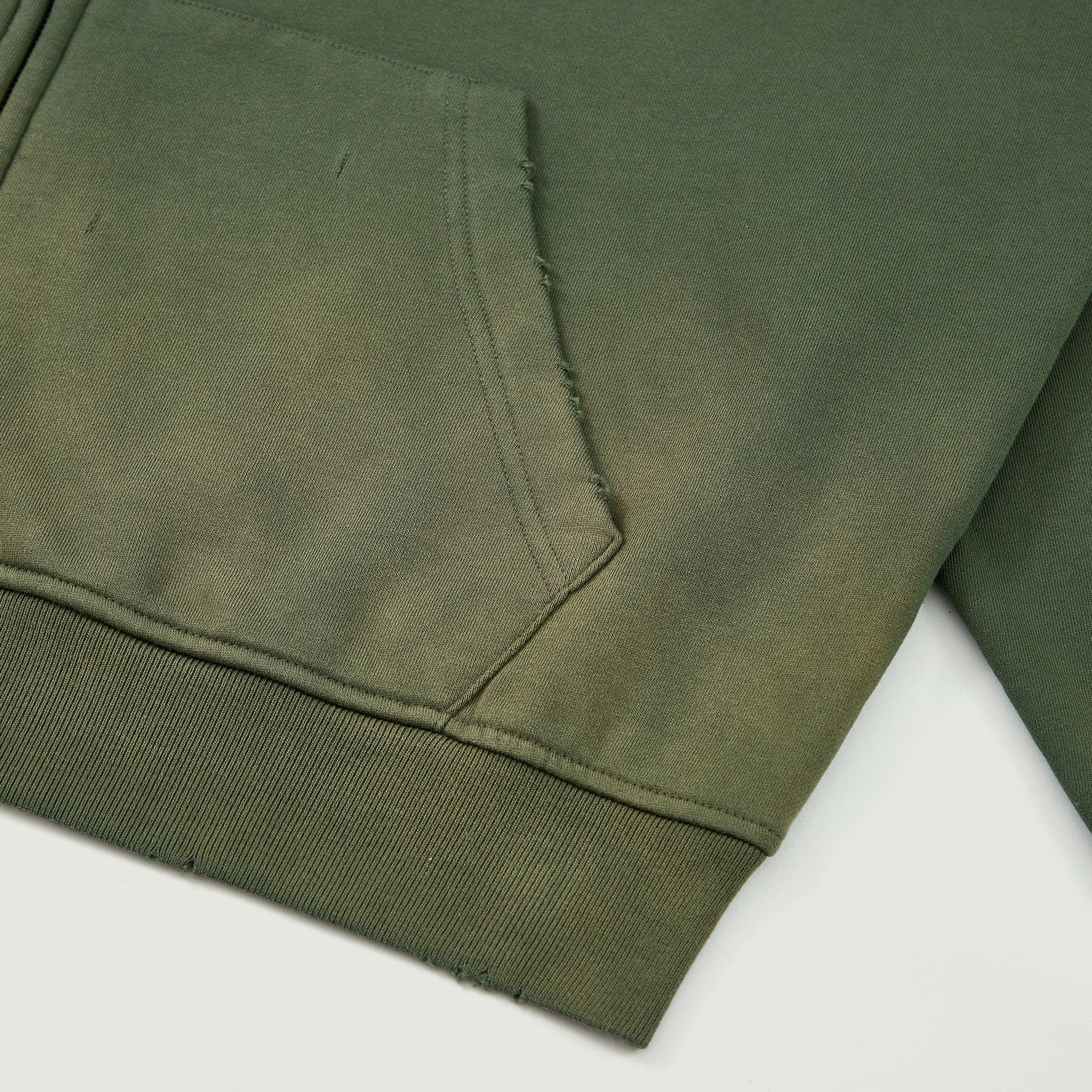 Eternal Wing media image showing green sample zip hoodie hem and pocket close-up detail