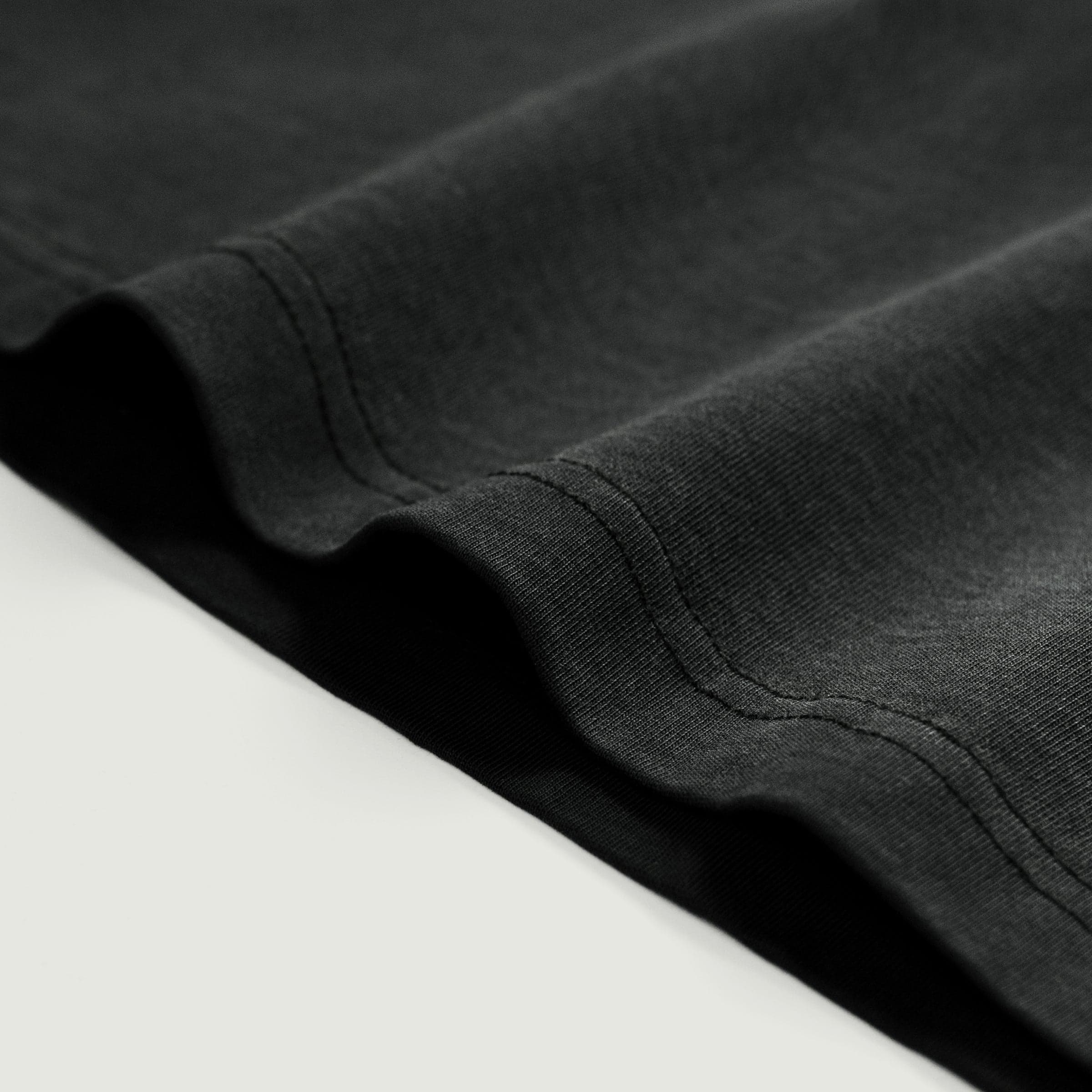 FALLEN GRACE media image showing washed dark grey hem close-up detail