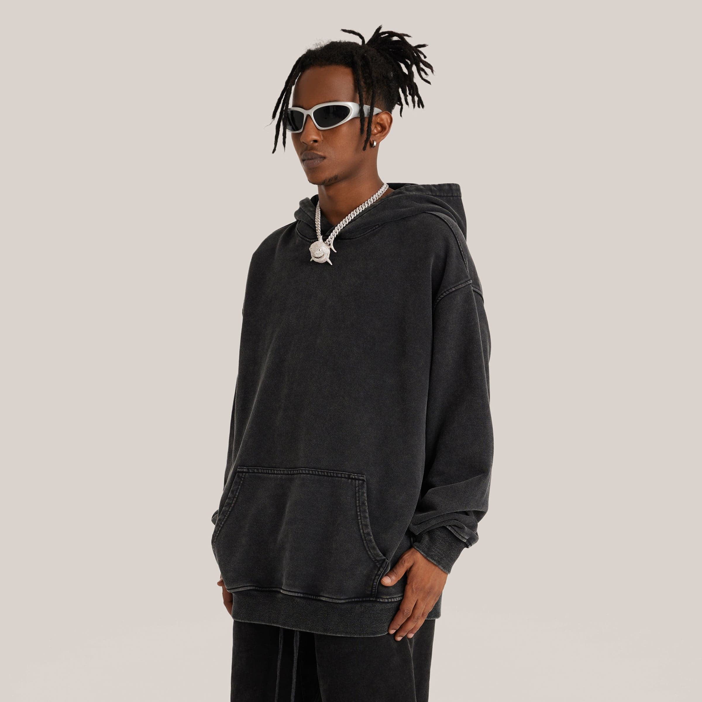 male model wearing washed black oversized hoodie side front view