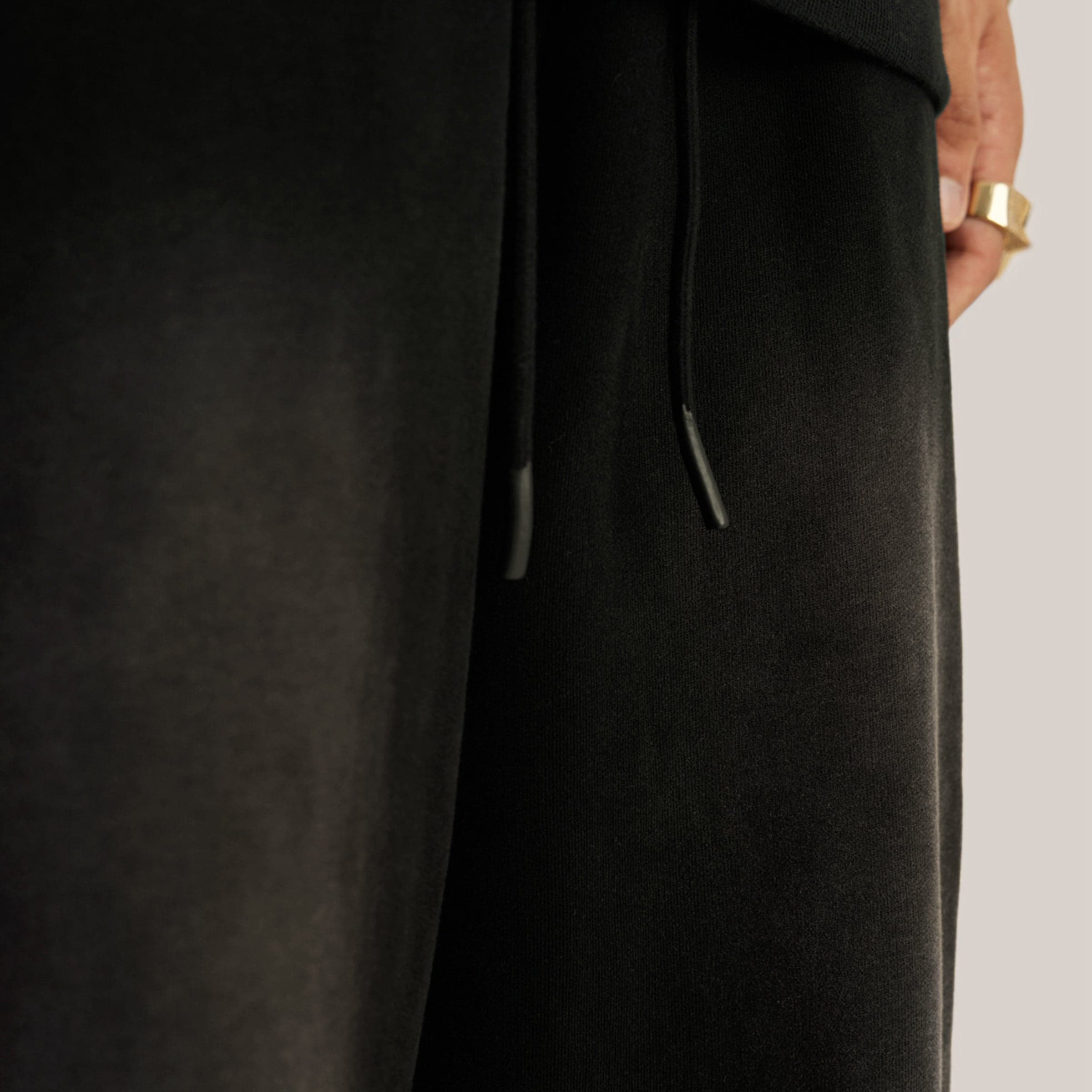 REIGN media image showing washed black sweatpants leg fabric close-up detail