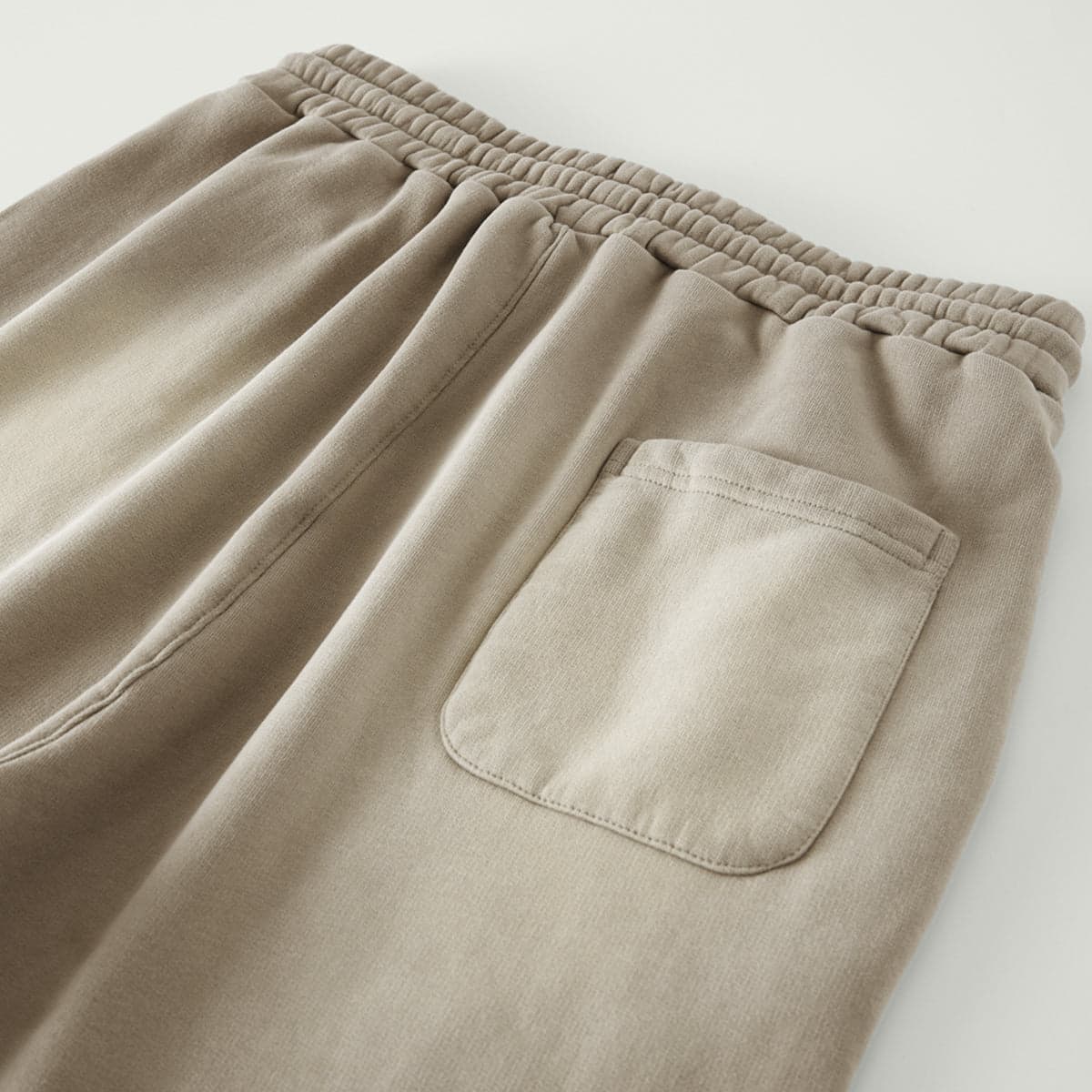 REIGN media image showing beige sample sweatpants rear patch pocket close-up detail