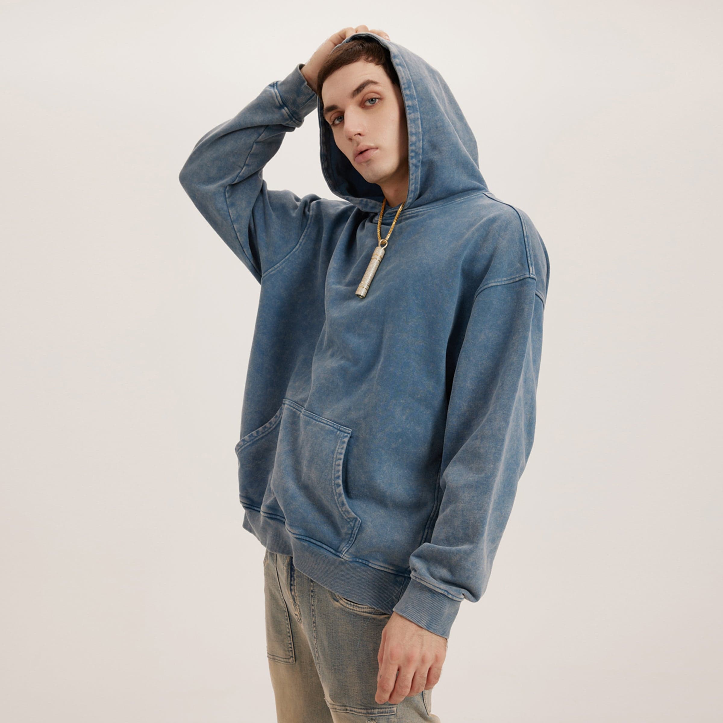 Retro Beat media image showing male model wearing a blue washed oversized hoodie angled front view