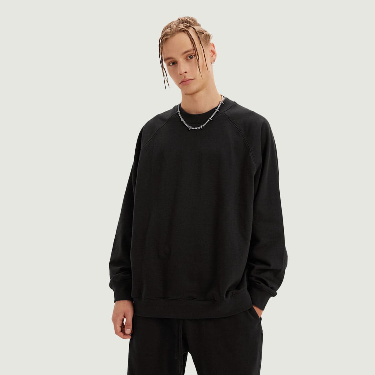 Sunflux media image showing male model wearing a black crewneck sweatshirt front view