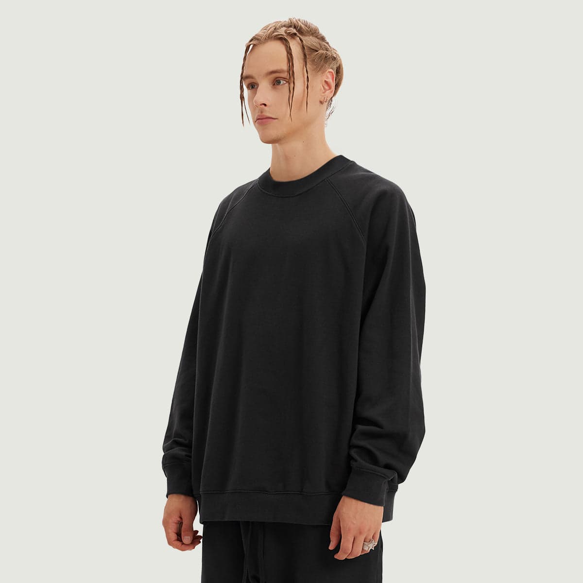 Sunflux media image showing male model wearing a black crewneck sweatshirt angled front view