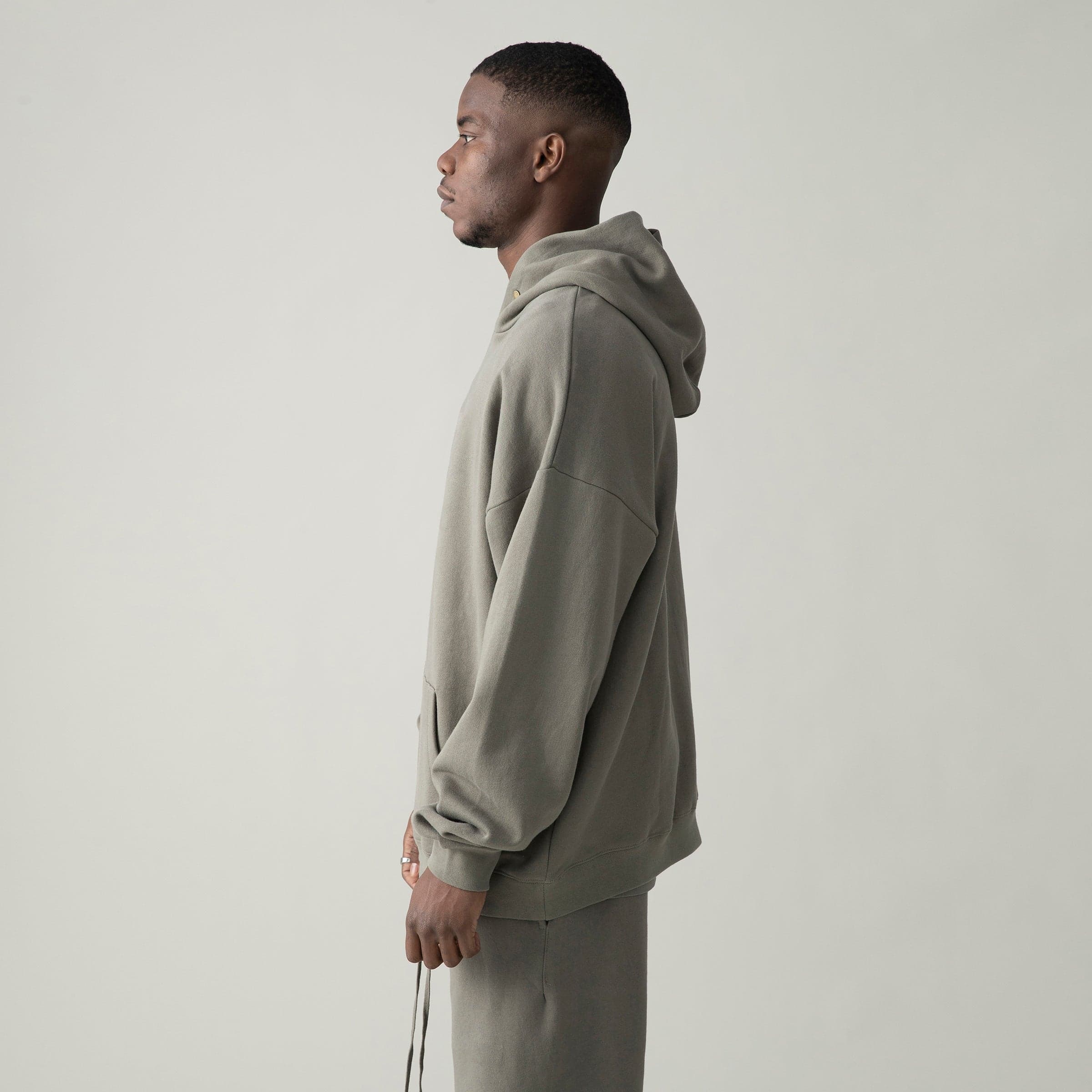 VineSigil media image showing male model wearing a taupe loose fit hoodie side view