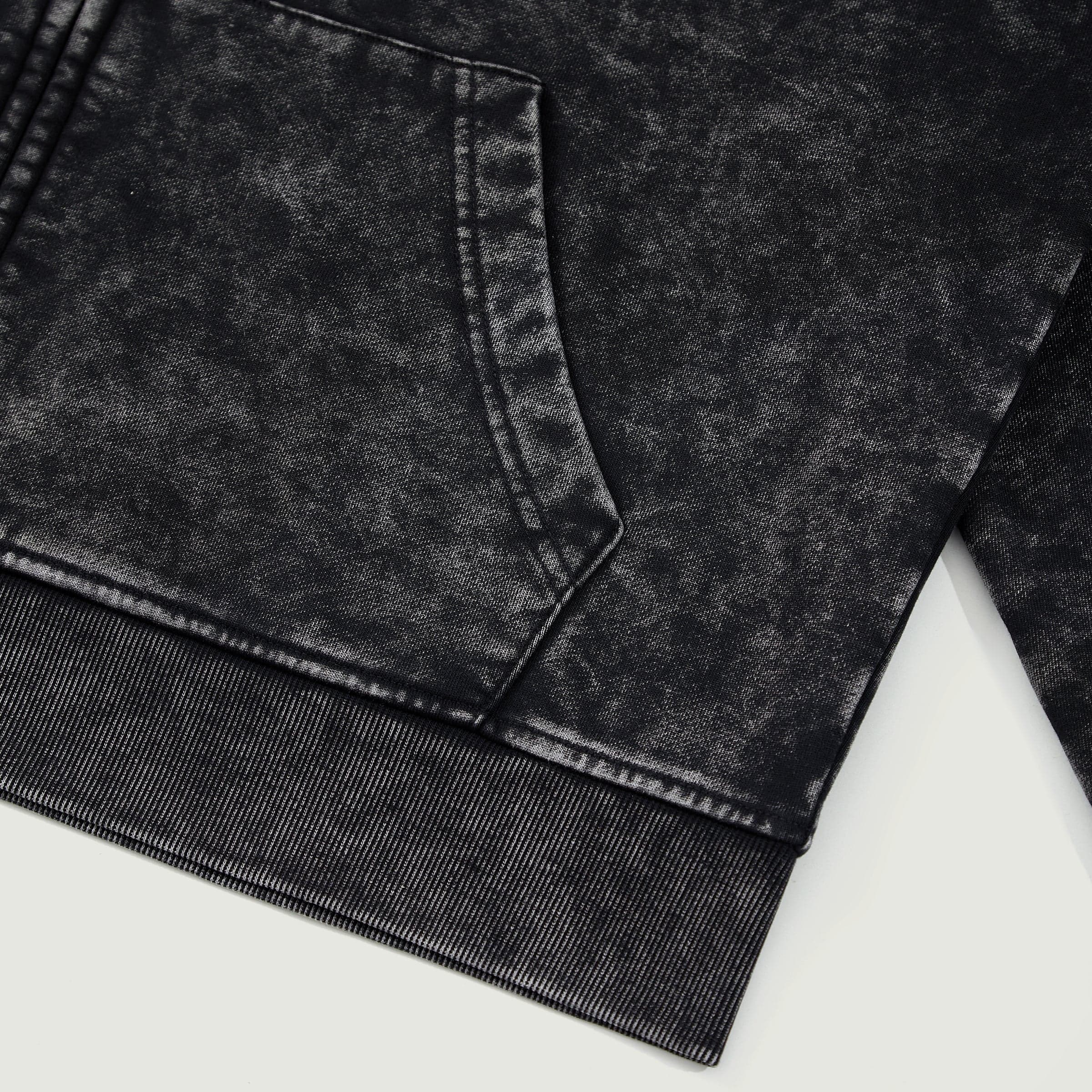 Winged Spear graphic zip up hoodie hem and pocket close-up detail in washed black cotton